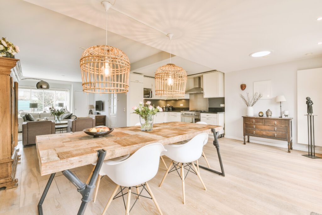Contemporary open plan kitchen with dining table set and gray sofa in light spacious room